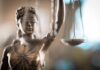 Police Barracks Nightmare Explodes Lady Justice statue holding scales