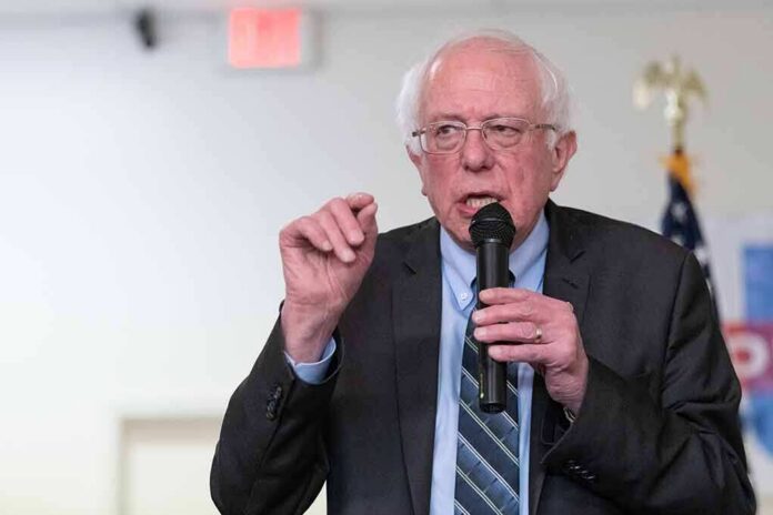 shutterstock_1324038956 Bernie Sanders speaking into a microphone at an indoor event