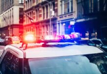 Police car with flashing lights in city street