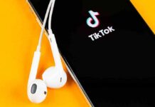 Clout-Chasing Ends In Handcuffs Smartphone with TikTok app and white wired earbuds on yellow background