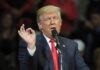 Trump Announces Massive Investment Donald Trump speaking at a rally with microphone and raised hand gesture