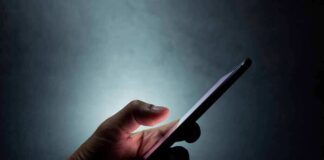 Hand holding a smartphone in the dark