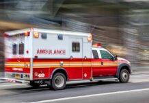 Driver Detained After Field Carnage Ambulance speeding down a city street with lights flashing