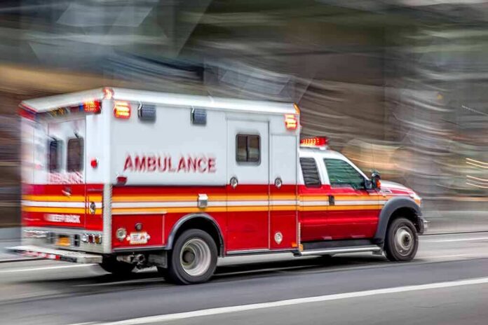 Ambulance speeding down a city street with lights flashing