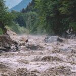 Walls Of Water Erase Villages And Bridges Flooded river gorge with fast muddy water and rocks