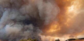Wildfire smoke billows over suburban houses