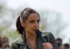 AOC speaking into a handheld microphone outdoors