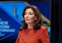 ICE Showdown Explodes In NY Debate Kathy Hochul speaking at a podium with microphones