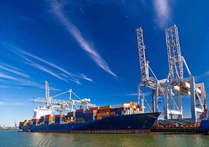 Container ship docked at port with cranes loading cargo