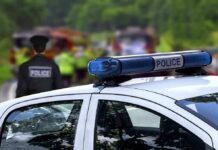 Fatal Standoff Inside Elementary Police car with blue light bar at roadside scene