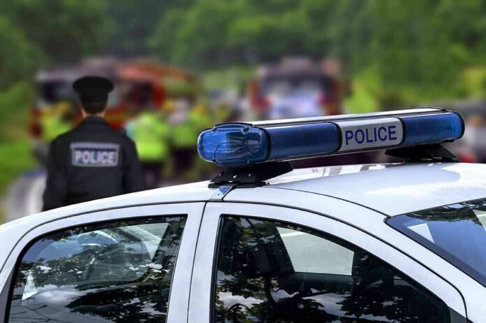 shutterstock_299407196 Police car with blue light bar at roadside scene