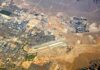War Crime Alarm After Airport Missile Shot Aerial view of desert city with airport and highways