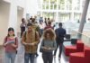 Campus Firestorm Erupts After 10 Seconds Students walking through a bright campus lobby using mobile devices