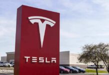 Livestream Hype, Five Figures Down Tesla dealership sign in front of parking lot