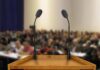 Podium with two microphones facing a blurred audience